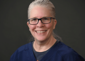 Headshot of Ann Graney , a professional dentist, with a welcoming smile in a clinical setting.