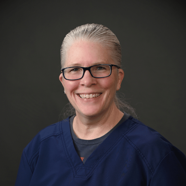 Headshot of Ann Graney , a professional dentist, with a welcoming smile in a clinical setting.