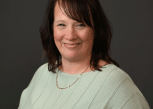 Headshot of Marihelyn Horrigan, the Community Impact Director, dressed in professional attire, with a confident and approachable expression in an office setting.